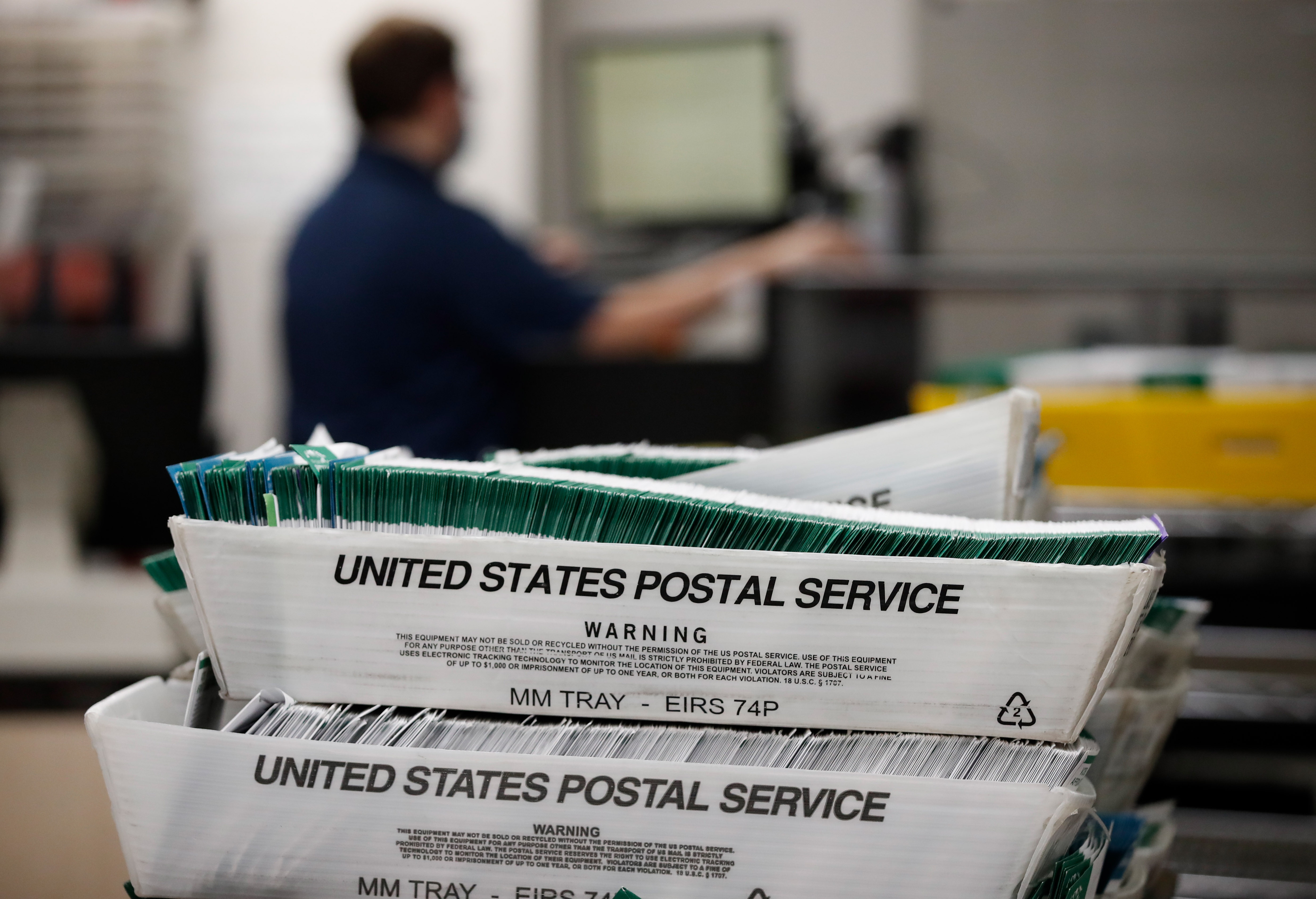 In this file photo, election workers stack ballots that were picked up at a U.S. Postal Service office to be processed in 2020 in Provo, Utah.